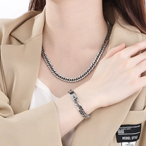 Polished silver stainless steel Cuban link chain necklace and bracelet on male model