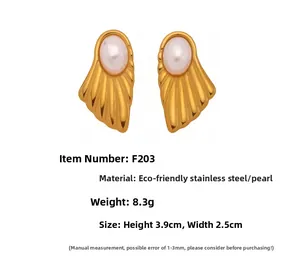 Detailed view of golden ripple-shaped earrings with inlaid white shell pearls, 3.9cm size