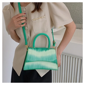 Fashionable green gradient crossbody bag worn with puff sleeve blouse on a model