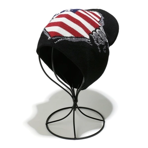 Detailed close-up of American flag jacquard pattern on a black knit earflaps beanie