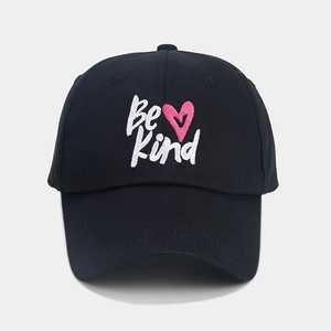 Detailed embroidery of Be Kind slogan and pink heart on black cotton baseball cap
