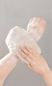 Exfoliating bath strap in action showing dense foam on arm with natural fiber texture
