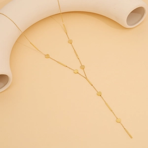 Detail of long Y-shaped golden stainless steel necklace with heart and bar charms