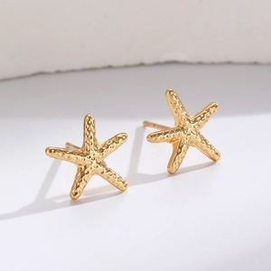 Detailed macro view of golden starfish ear cuffs with realistic hammered metal texture