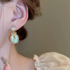 French vintage oval earrings with green tulip design and pearl stud detail on ear