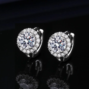 Macro detail of silver halo hoop earrings with shimmering cubic zirconia on black background