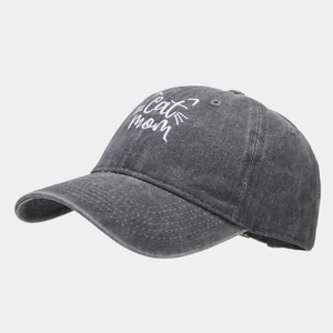 Close-up of cat mom embroidery and washed distressed fabric on dark gray baseball cap