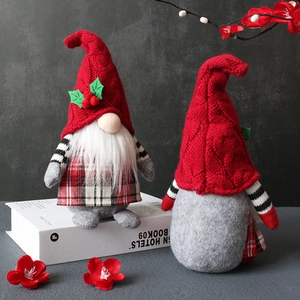Christmas plush gnomes with red knit hats and checkered bodies on white books