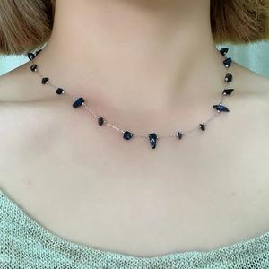 Detailed view of irregular dark blue natural stone pendant on a slim silver chain