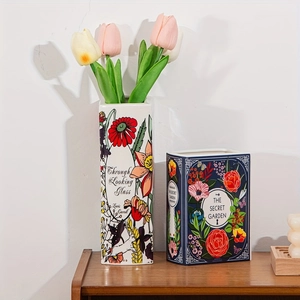 Detail of book-shaped ceramic vase with Alice in Wonderland and Secret Garden floral motifs
