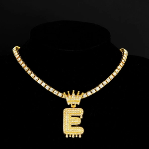 Dettaglio del pendente hip hop lettera E dorata con corona e catena tennis