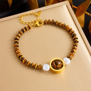 Tiger eye stone beaded bracelet with golden heart pendant and pearls on a jewelry stand