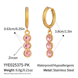 Macro view of gold stainless steel huggie earrings with three pink zircon stones details