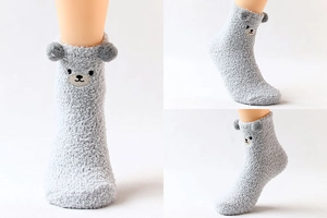 Détail de chaussettes en polaire corail grise avec oreilles 3D et broderie d'ours