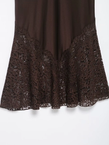 Detailed view of dark brown satin midi skirt hem featuring delicate lace patchwork edge