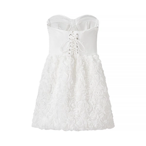 Detailed back view of white corset dress with lace-up ties and 3D floral skirt