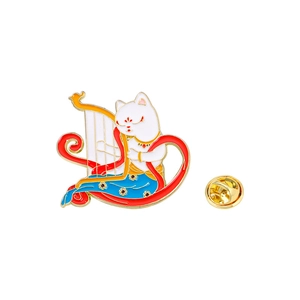 Macro shot of cat playing harp enamel pin with gold butterfly clutch and vibrant colors