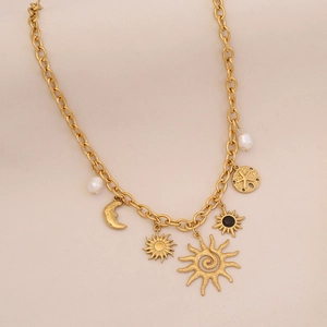 Detailed shot of gold plated necklace with moon, sun, and pearl pendants on link chain