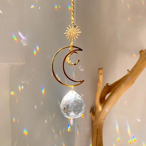 Detail of sun and moon crystal suncatcher reflecting colorful rainbows on a wall