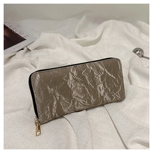 Macro shot of grey pleated faux leather texture and metallic zipper on a long wallet