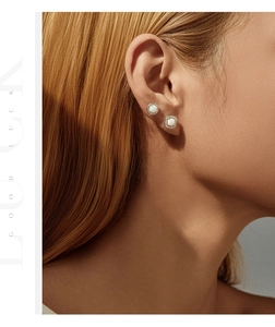 Close-up of S925 silver stud earrings with synthetic opal and sparkling zircon halo