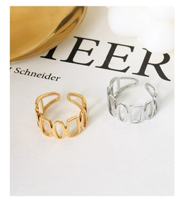 Detail of interlocking hollow geometric chain rings in gold and silver finishes