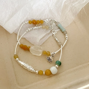 Détail de bracelets en argent S925 avec perles de jade et pendentif lotus