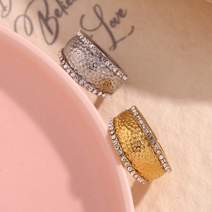 Detail of 18K gold and silver rings with hammered texture and side diamond accents