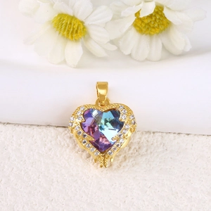 Detailed shot of a gold heart pendant with purple gradient gemstone and micro-pave crystals