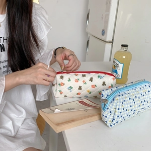 Detailed view of cute floral and checkered quilted cosmetic bags used by a girl