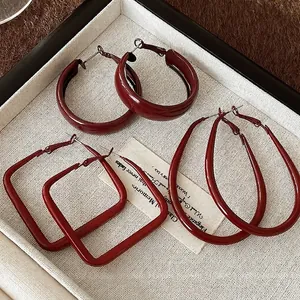 Retro deep red round and square hoop earrings set in matte finish on woven display
