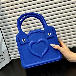 Detailed view of blue EVA handbag featuring 3D heart patterns and matte texture finish
