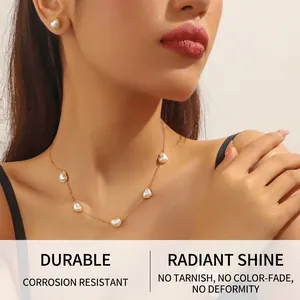 Détail d'un ensemble de bijoux cœur dorés avec nacre portés par un mannequin élégant