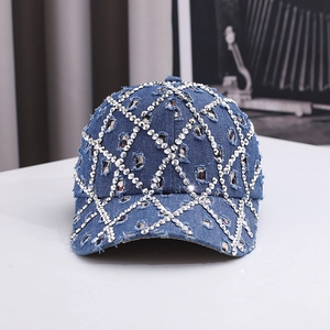 Close-up of blue denim baseball cap with silver rhinestones and distressed ripped details