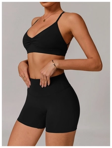 Close-up of black V-neck sports bra with ruched detail and high-waist yoga shorts set