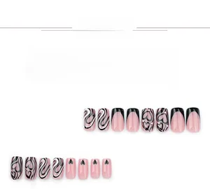 Detail of French press-on nails with black heart patterns and rhinestone accents