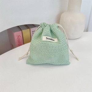 Close-up of mint green waffle fabric drawstring pouch with refined woven texture