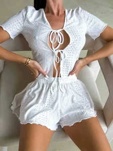 Detail view of white eyelet lace pajama set featuring tie-front cardigan and shorts