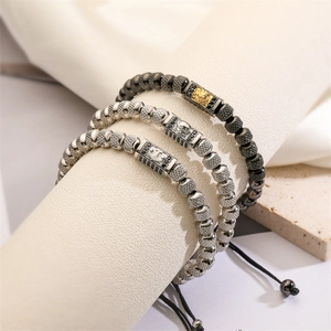 Macro detail of men's beaded bracelets with lion head beads and woven adjustable rope