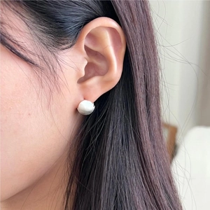 Minimalist matte sterling silver ball stud earrings with brushed texture on female ear
