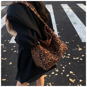 Detailed view of leopard print tote bag texture and large capacity on an autumn street