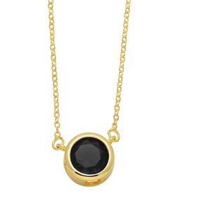 Détail macro d'un collier plaqué or avec un pendentif rond serti d'un zircon noir chic