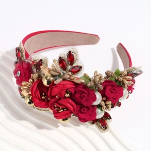 Gros plan de roses en tissu rouge et perles sur un serre-tête floral de style baroque