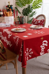 Macro shot of red Christmas tablecloth with snowflake prints and Merry Christmas text
