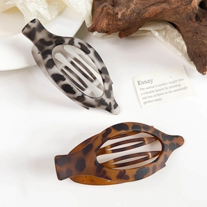 Close-up of leopard print matte hair claws in grey and brown for French twist styles