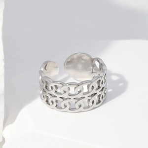 Polished double chain link stainless steel open ring on a minimalist white stone base