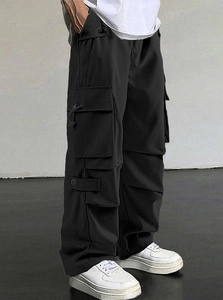 Side view of men's black parachute cargo pants showing large flap pockets and loose fit