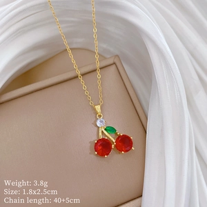 Detail view of red cherry crystal pendant on golden chain with size and weight specs