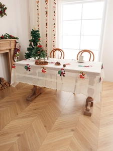 Detail of Christmas tablecloth with Santa embroidery and hollow lace edges