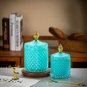 Detail of two turquoise glass jars with diamond texture and pointed gold lids